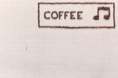 Coffee word and music note made of roasted beans inside border on linen surface, aligned top rightの写真素材