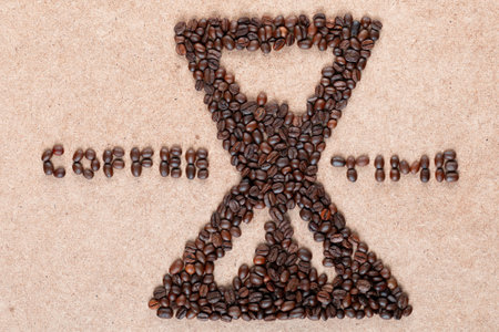 Bunch of coffee beans forming a sand clock with coffee time inscription on plywood, aligned in centerの写真素材