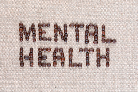 Mental health inscription made of roasted coffee beans placed on creamy linen texture, shot close upの写真素材