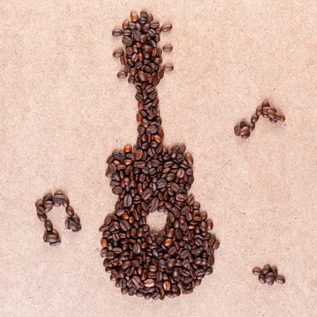 Guitar and musical notes made of roasted coffee beans on plywood, shot from aboveの写真素材