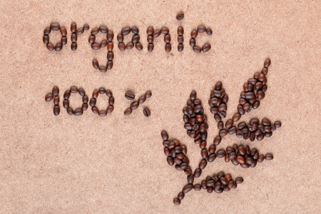 Coffee branch and inscription promises 100% organic made of roasted beans on plywood surfaceの写真素材