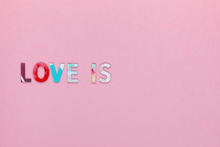 Inscription Love Is on pink textured background, aligned middle leftの写真素材