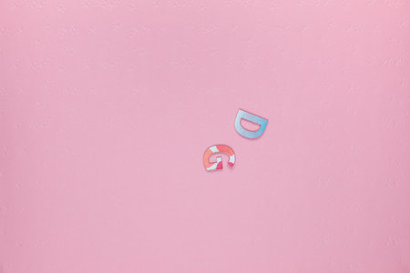 Letters D and G on light pink textured backgroundの写真素材