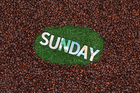 Sunday written with colorful letters on artificial grass surrounded by roasted coffee beansの写真素材