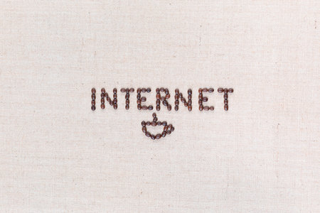 The word internet written with coffee beans on creamy linea canvas, shot from above , aligned in the center.の写真素材