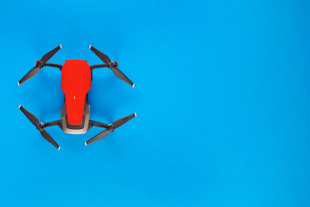 A red drone on blue background, shot from above, aligned to the left.の写真素材