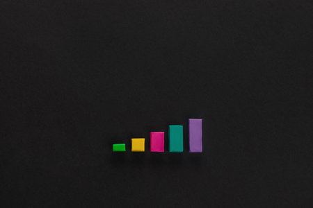 A graph made from colorful columns of plasticine on black background, shot from above.の写真素材