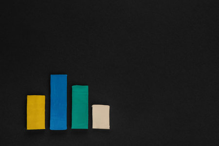 A graph made from colored columns made from plasticine on black background, shot from above.の写真素材