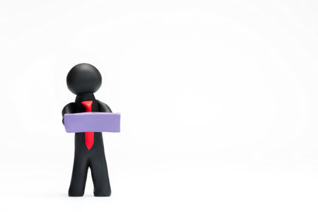 A man made from black plasticine holding a purple blank sheet of paper on white background, aligned to the left.の写真素材