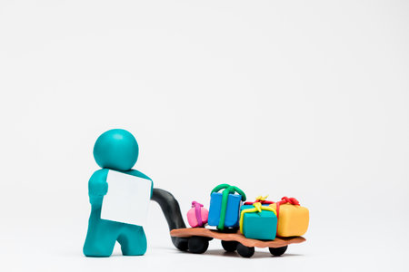 A man made from blue plasticine bringing a pile of gifts on white background, aligned in the center.の写真素材