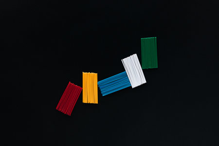 Packs of matching sticks on a black background, shot from above, arranged in the center.の写真素材