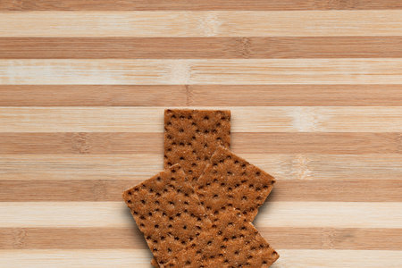 Slices of bread arranged close to one another on a brown table, shot from above.の写真素材