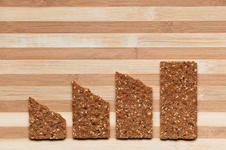 Slices of bread arranged close to one another on a brown table, shot from above.の写真素材