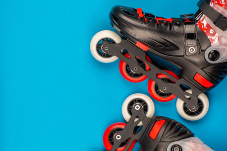 A pair of roller red roller skates on blue background, shot from above.の写真素材