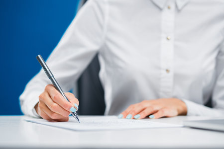 Businesswoman writing down on a sheet of paper new and innovative ideas.の写真素材