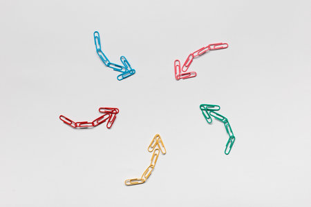 Many small colorful arrows pointing towards the center on white background, shot from above, closeup.の写真素材