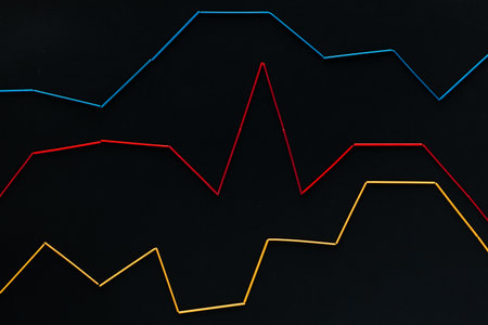 Three graphs of different colors on a black background , shot from above.の写真素材
