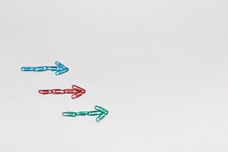 Many small colorful arrows pointing towards the right on white background, shot from above.の写真素材