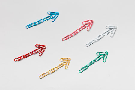 Many small colorful arrows pointing upwards on white background, shot from above, closeup.の写真素材