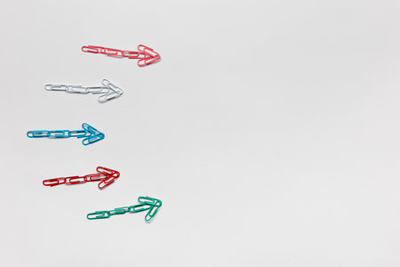 Many small colorful arrows pointing towards the right on white background, shot from above.の写真素材