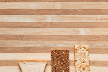 Slices of bread arranged close to one another on a brown table, shot from above.の写真素材