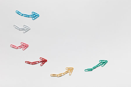 Many small colorful arrows pointing upwards on white background, shot from above.の写真素材
