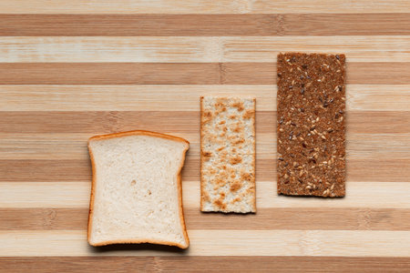 Slices of bread arranged close to one another on a brown table, shot from above.