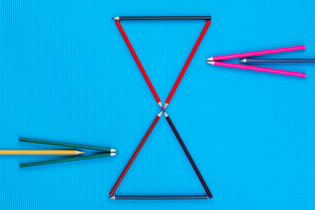 A bunch of colorful crayons forming arrows on an ocean blue background, shot from above.の写真素材