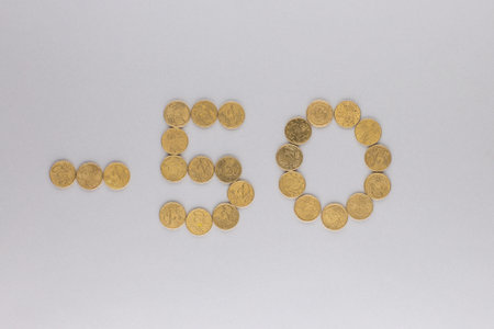 -50 made from gold coins shot from above, on white background.の写真素材