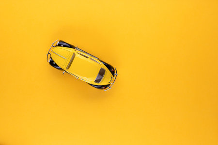 An yellow car figurine shot from above, on yellow background, aligned to the left.の写真素材