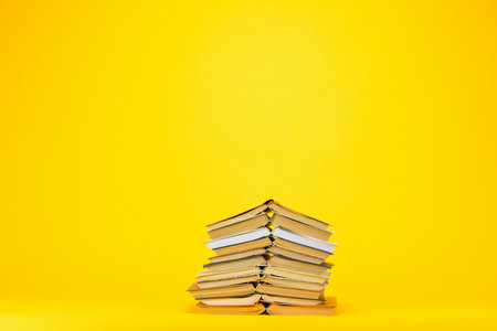 A column of old and fascinating books on yellow background.の写真素材