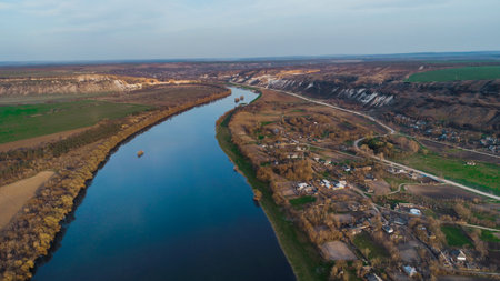 Beautiful shot of a blue river and a moldavian village to it's right.の写真素材
