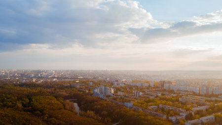 Shot of a beautiful city located at the edge of a forest, and a cloudy white sky, during a majestic sunrise.の写真素材
