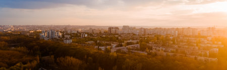 A beautiful city located at the edge of a forest, of a cloudy blue sky, shot from above during a majestic sunrise.の写真素材