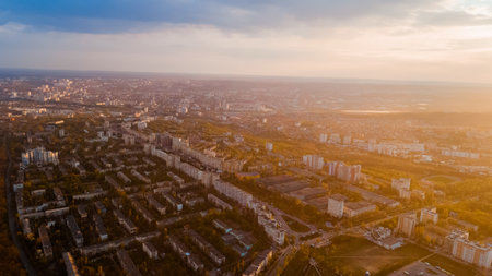 A beautiful city located at the edge of a forest, of a cloudy blue sky, shot from above during a majestic sunrise.の写真素材
