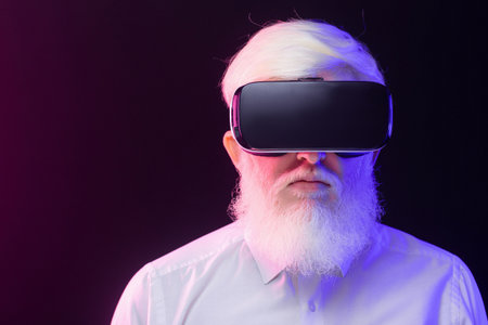 Closeup view of an old albino man wearing a vr set, isolated on a beautiful, colorful background.の写真素材