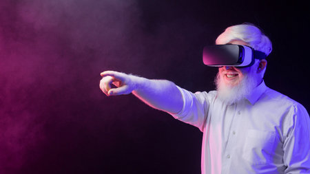 Portrait of an old albino grandfather pointing to the left, wearing vr isolated on a beautiful, colorful background.の写真素材
