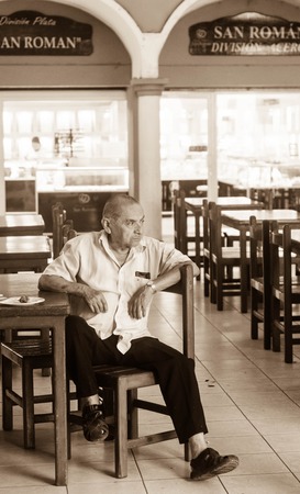 Mexican adult male sitting alone at table in market placeのeditorial素材