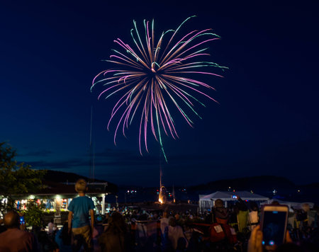 Fireworks display at Bar Harbor July 4th weekend celebrations with crowd in foreground and child...