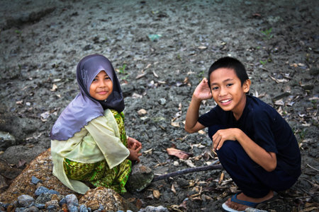 Balik Pulau, Sungai Burung - August 5, 2011: Children catching baby crabs in fishing village before sunset.のeditorial素材