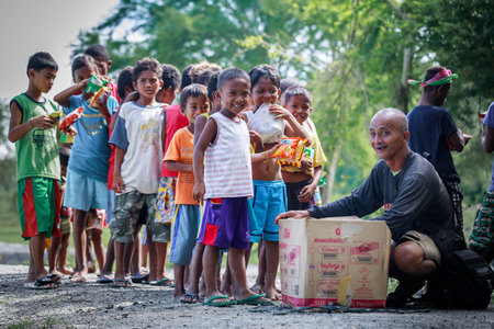 Filipino children standing in a line and holding snack in their hands on Aug 27 2017 in Santa Juliana, Capas, Central Luzon, Philippinesのeditorial素材