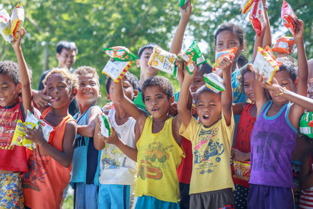 Filipino children standing in a line and holding snack in their hands on Aug 27 2017 in Santa Juliana, Capas, Central Luzon, Philippinesのeditorial素材