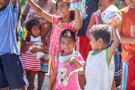 Filipino children standing in a line and holding snack in their hands on Aug 27 2017 in Santa Juliana, Capas, Central Luzon, Philippinesのeditorial素材