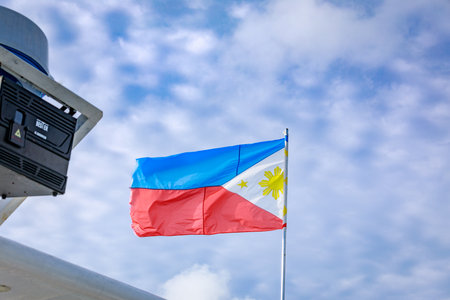Philippine flag on a pole against blue skyの写真素材