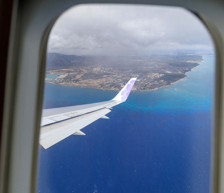 Honolulu, Hawaii - Dec 22, 2018 : Wing of Hawaiian Airlines plane flying in the air above Honoluluのeditorial素材