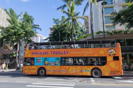 Honolulu, Hawaii - Dec 23, 2018 : Waikiki Trolley bus on Kalakaua avenue, Waikiki beach