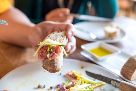 Man hand holding Beef carpaccio with breadの写真素材