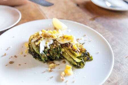 roasted little gems with egg, anchovy, breadcrumbsの写真素材