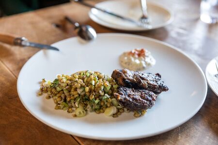 lamb cheeks with couscous on the tableの写真素材