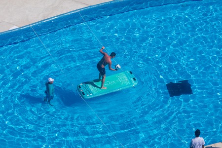 Cancun, Mexico - Aug 30, 2019 : Man playing with ball in swimming pool at Beach Palace resort and...